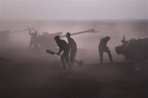 Syrian army personnel load howitzers near the village of Morek Syria on Wednesday Oct. 7 2015. The Syrian army has launched an offensive against rebels earlier in the week in central and northwestern Syria aided by Russian airstrikes. (Alexander Kots