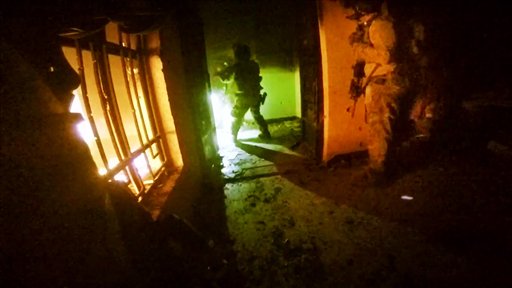 This image made from video taken on Thursday Oct. 22 2015 from a helmet camera shows U.S. and Iraqi special forces freeing hostages from a prison controlled by Islamic State militants in the town of Huwija 15 kilometers west of the Iraqi cit