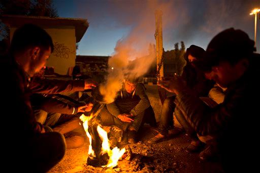 Afghan refugees gather around a fire to warm themselves from the morning cold at the port of Mitylene on the northeast Greek island of Lesbos while waiting to get on board a ferry traveling to Athens early Friday Oct. 9 2015. More than 500,000 people