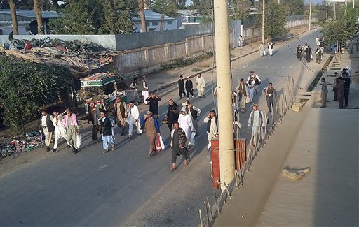 Taliban prisoners walk on a street after their comrades released them from the main jail in Kunduz north of Kabul Afghanistan Monday Sept. 28 2015. The Taliban captured the northern Afghan city of Kunduz in a massive assault Monday involving hundreds