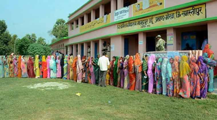 Voters wait in queue to cast their votes at a polling station in Samastipur on Monday during the first phase of Bihar assembly elections