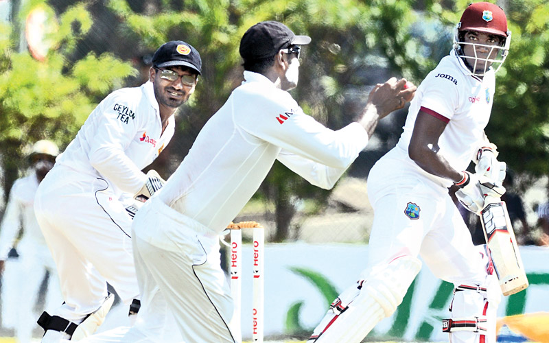 Skipper Angelo Mathews takes a catch in the slips to dismiss West Indian Jerome Taylor for 31 off the bowling of Tharindu Kaushal