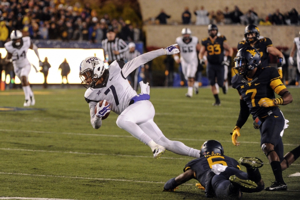 TCU's Kolby Listenbee is tackeled by West Virginia defender Dravon Henry during the fourth quarter of an NCAA college football game in Morgantown