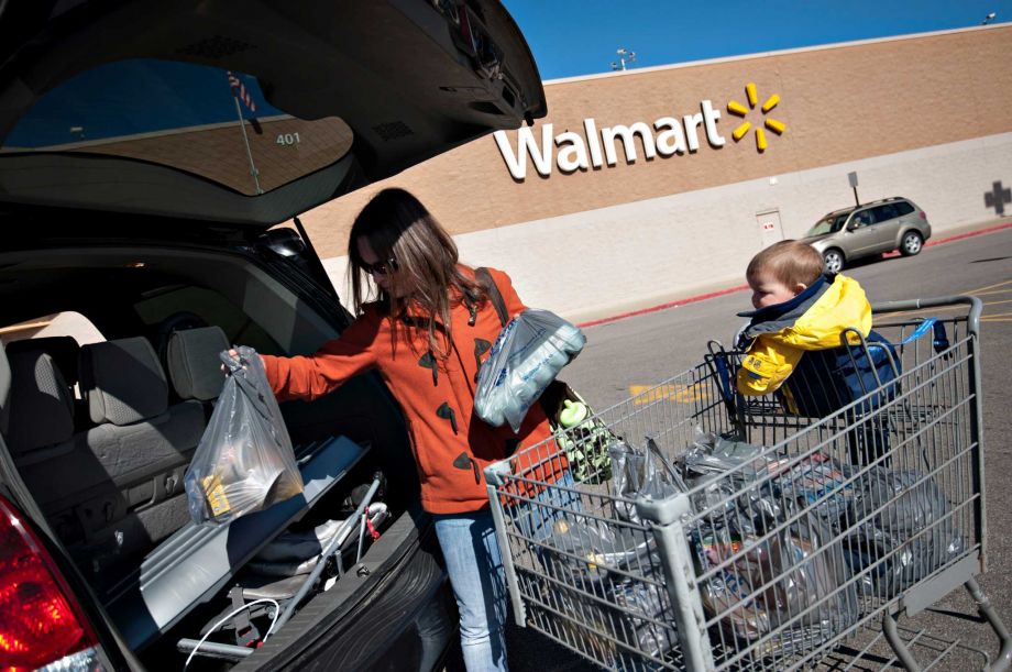 Customer Jen Dickinson unloads groceries as her son Jack 15-months looks on outside a Wal Mart store in East Peoria Illinois U.S. on Wednesday Feb. 20 2013. Wal Mart Stores Inc. the worldâs largest retailer projected first-quarter profit tha