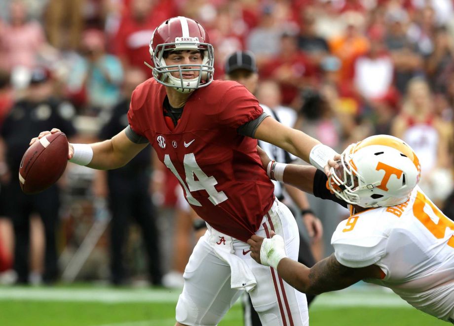 Alabama quarterback Jake Coker stiff arms Tennessee defensive end Derek Barnett as he tries to get away from pressure during the second quarter of an NCAA college football game Saturday Oct. 23 2015 in Tuscaloosa Ala