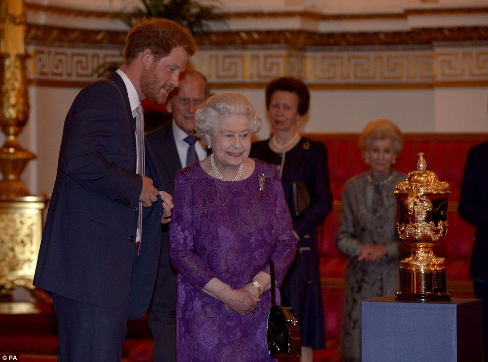 Wistful The Queen and Prince Harry admired the Webb Ellis Cup as they welcomed Rugby World Cup to Buckingham Palace