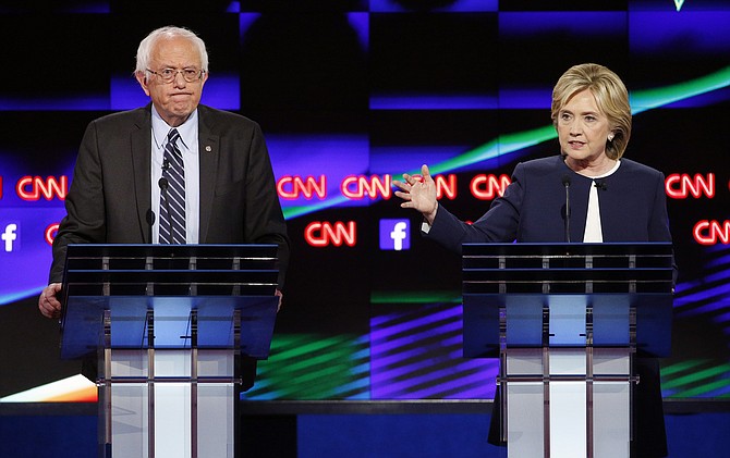 Hillary Rodham Clinton right speaks as Sen. Bernie Sanders I-Vt. listens during the CNN Democratic presidential debate Tuesday Oct. 13 2015 in Las Vegas. Clinton and Sanders clashed over U.S. involvement in the Middle East gun control and economic