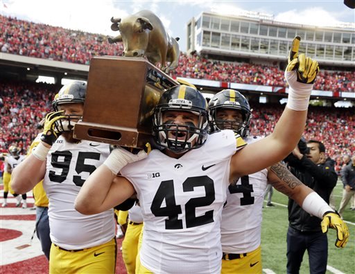 Iowa's Drew Ott, Macon Plewa and Nate Meier carry the Heartland Trophy after their 10-6 win over Wisconsin in an NCAA college football game Saturday Oct. 3 2015 in Madison Wis