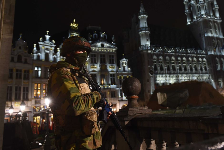 A Belgian soldier stands guard as a police raid takes place around the Grand Place in Brussels