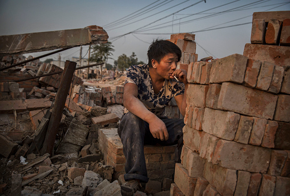 A Chinese laborer smokes as he takes a break in Gucheng Village Tongzhou District Beijing on Oct. 15 2015