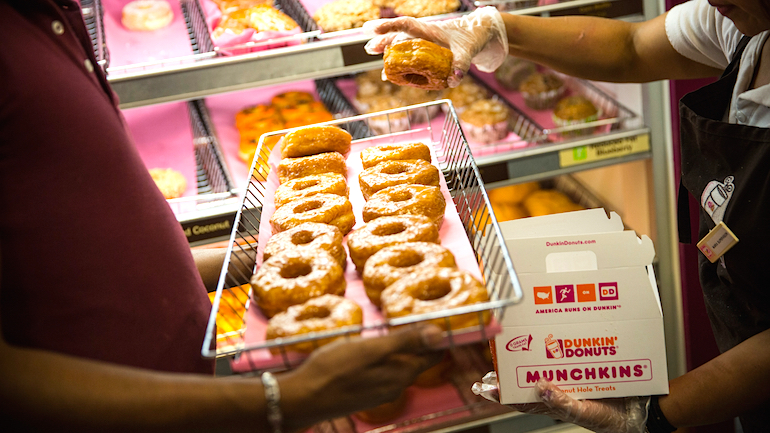 A Dunkin&#039 Donuts employee places a 'croissant doughnut&#039 in a box