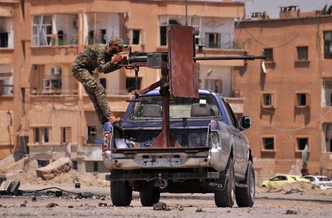 A Syrian Kurdish YPG fighter mans a machine gun in the province of Hasakah