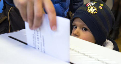 A child looks at a ballot being cast at a polling station in Zagreb Croatia on Nov. 8 2015. /AP