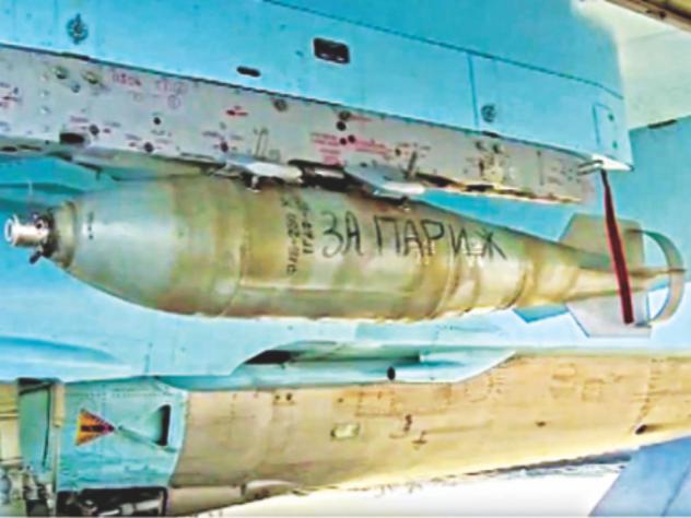 A ground crew member writing words'For Paris on bomb on a Russian military jet at Hmeimim air base in Syria