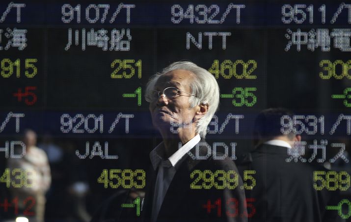 A man is reflected on the electronic board of a securities firm in Tokyo Japan Friday Nov. 6 2015