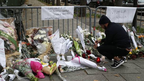 A man lights a candle outside the Bataclan theatre in Paris