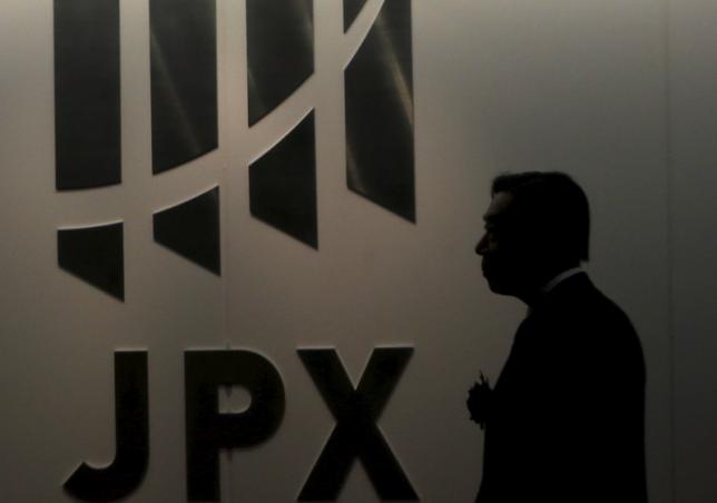 A man walks past the logo of Japan Exchange Group Inc. at the Tokyo Stock Exchange in Tokyo