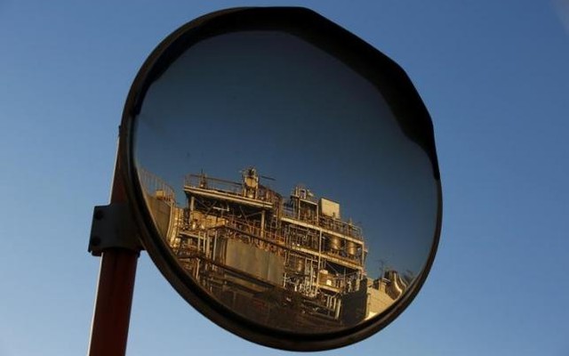 A petro-industrial factory is reflected in a traffic mirror in Kawasaki near Tokyo Dec 18 2014. Reuters