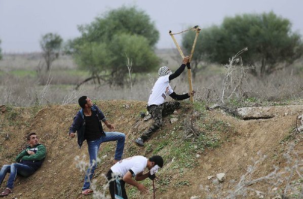 ADEL HANA						Credit AP				Palestinians sling stones toward Israeli security forces during clashes Friday on the Israel Gaza border