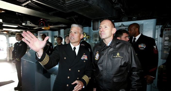 Australian Prime Minister Tony Abbott right speaks to Captain Kyle P. Higgins onboard the USS Blue Ridge as she arrives in Sydney Harbour Australia Friday