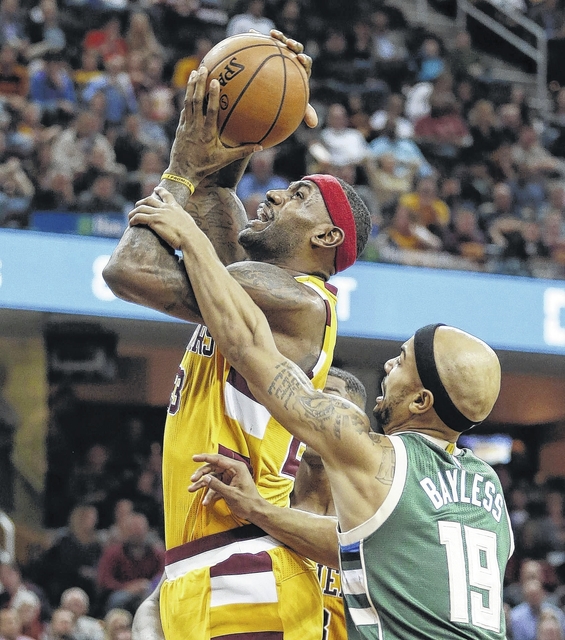 Bron James left is fouled by Milwaukee’s Jerryd Bayless Thursday’s game in Cleveland