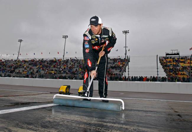 A pit crew member pushing water from his team's stall Sunday at soggy Phoenix Raceway