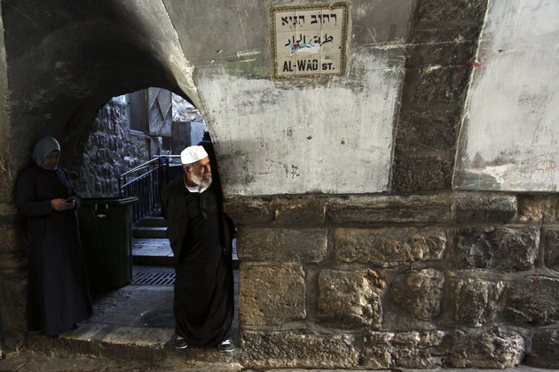 Palestinians look at the scene after a stabbing attack in Jerusalem's Old City