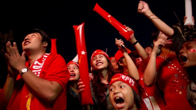 Supporters of Myanmar opposition leader Aung San Suu Kyi celebrate as they look at the official election results outside the National League of Democracy headquarters in Yangon