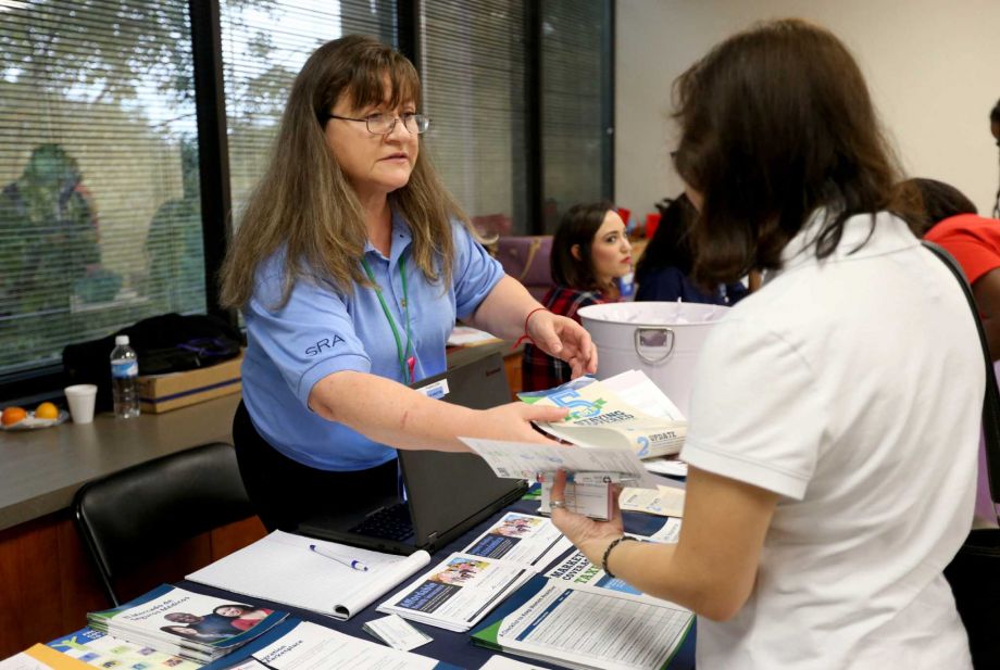 Majorie Monson in person assister with Houston North Enrollment Assistance Center hands out information about the Affordable Care Act federal marketplace insurance benefits at the the Houston Lesbian Health Initiative event held at the Houston Area Comm