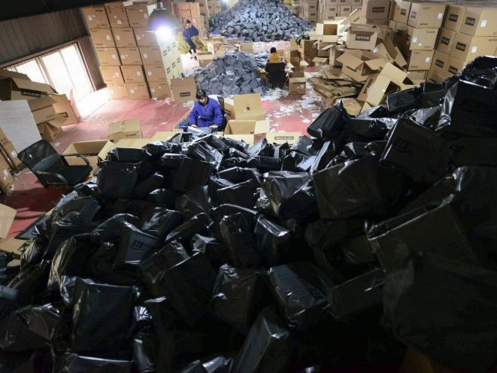 Employees sort packages at a hub of Shentong Express delivery company in Jiujiang Jiangxi province