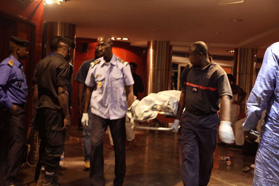 Mali security personal carry the body of a victim inside the Radisson Blu hotel after an attack by gunmen on the hotel in Bamako Mali Friday Nov. 20 2015. Islamic extremists armed with guns and grenades stormed the luxury Radisson Blu hotel in Mali's