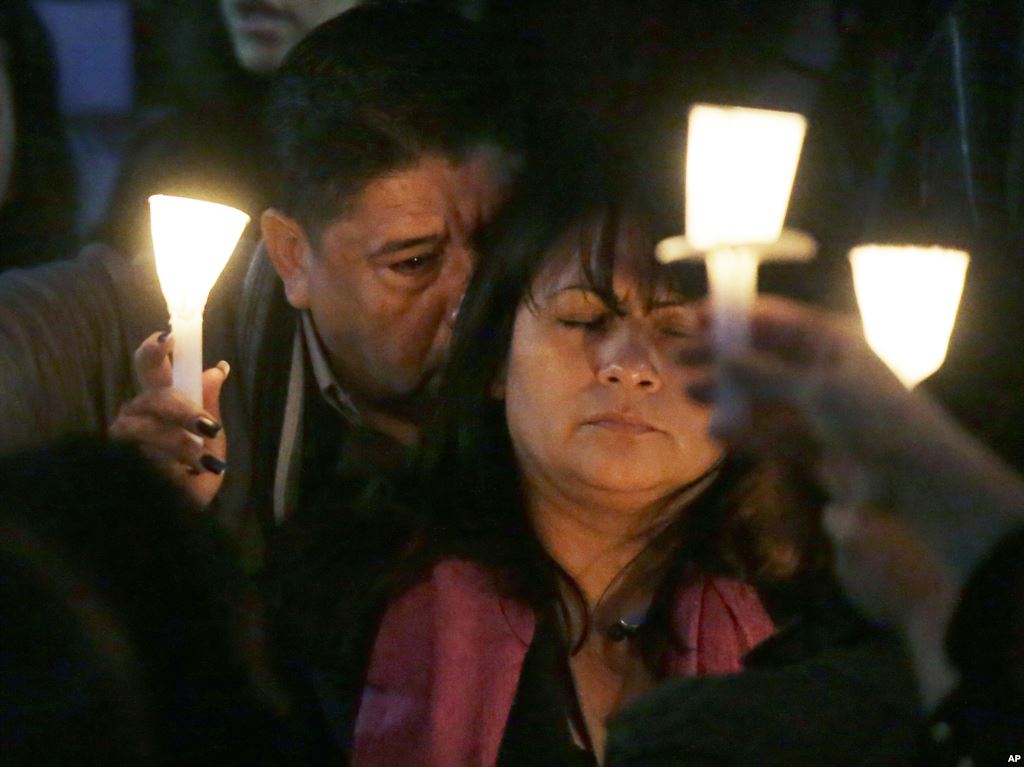 Beatrez Gonzalez right mother of California State Long Beach student Nohemi Gonzalez holds up candle with Nohemi's step-father Jose Hernandez left during a memorial service on Sunday Nov. 15 2015