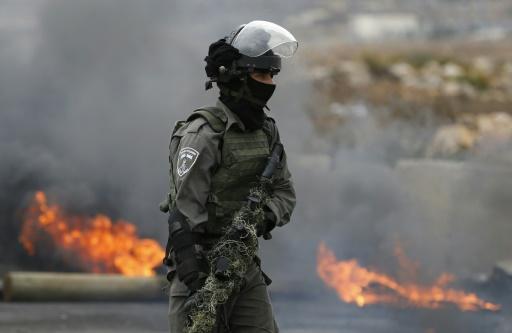 An Israeli border guards holds a camouflaged weapon during clashes with Palestinian youths in the West Bank town of Al Bireh