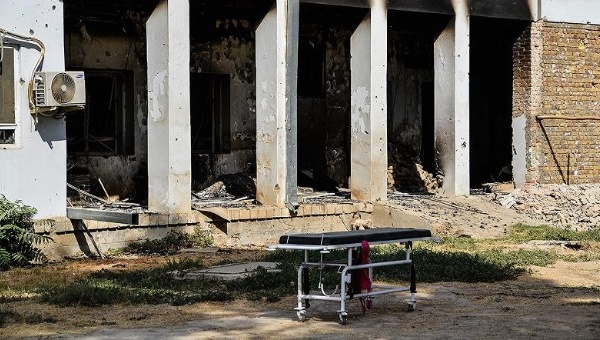 An emergency trolley bed lies abandoned in front of the heavily damaged entrance of the physiotherapy department