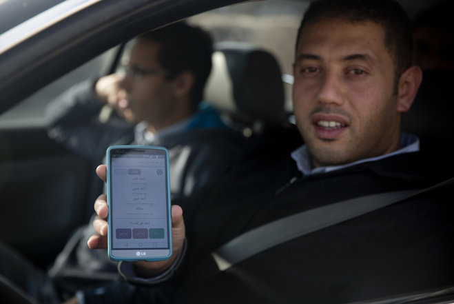 Palestinian driver shows the œAzmeh  application which means traffic jam in Arabic on his mobile phone as he waits in traffic to enter Jerusalem at Qalandia checkpoint between Jerusalem and the West Bank cit