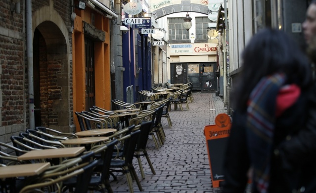 Tourists look down a side street off the normally bustling Rue des Bouchers in central Brussels Monday