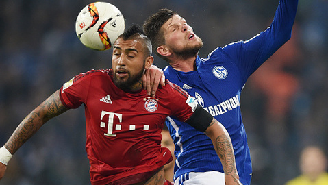 Arturo Vidal of Muenchen jumps for a header with Klaas Jan Huntelaar of Schalke