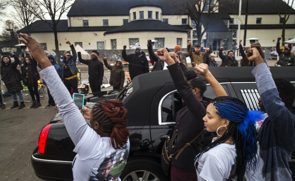 Family members of Jamar Clark show support for Black Lives Matter demonstrators as Clark’s funeral procession passes the Minneapolis 4th Precinct police station on Wednesday. Clark was fatally shot Nov. 15 in a scuffle with police