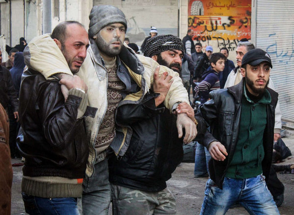 Syrian citizens help an injured man after airstrikes believed to be carried out by Russian warplanes in the center of Ariha town in the northwestern province of Idlib Syria. At least 18 civilians were killed in airstrikes Sunday