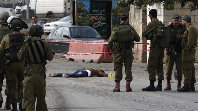 Israeli forces stand next to the body of a Palestinian by the illegal settlement of Kiryat Arba the occupied West Bank