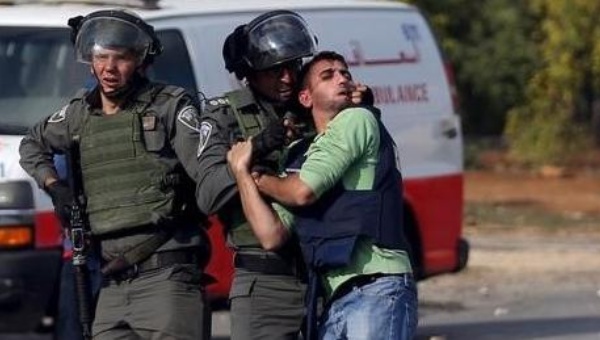 Israeli border police appear to beat a Palestinian journalist during clashes with Palestinian protesters near the Jewish settlement of Bet El near the West Bank city of Ramallah