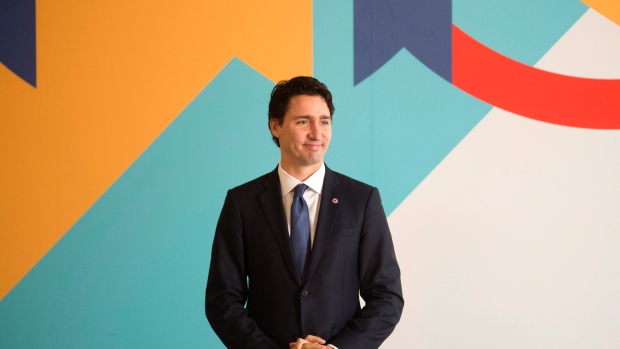 Canadian Prime Minister Justin Trudeau stands in his position as he waits for other leaders to take their places for a family