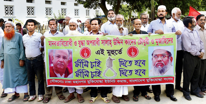 Bangladeshi freedom fighters who fought in the 1971 war hold a banner asking for the death penalty for Salauddin Quader Chowdhury and Ali Ahsan Mohammad Mujahid. File Pic  AFP