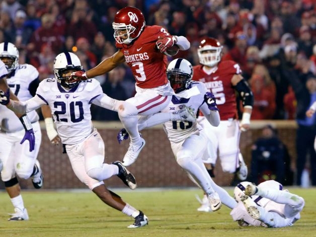 Oklahoma wide receiver Sterling Shepard leaps to avoid as TCU linebacker Montrel Wilson and others chase him during the third quarter of an NCAA college football game in Norman Okla. Saturday Nov. 21 2015. Oklahoma won 30-29