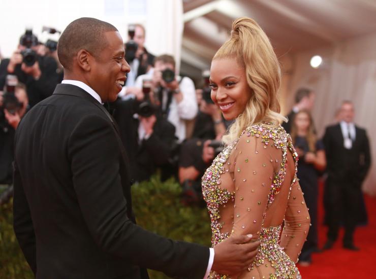 Singer Beyonce smiles next to her husband rapper Jay Z