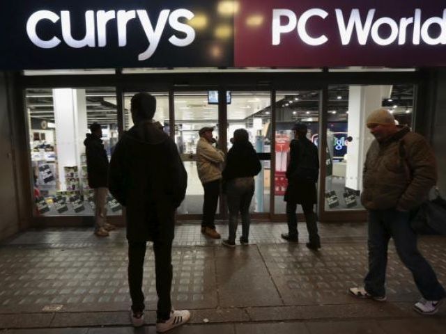 People wait outside a Currys PC World shop before the early opening of the Black Friday sales on Tottenham Court Road in London