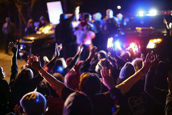 Some demonstrators sat down in the street as others chanted at Minneapolis police officers at the side entrance to the 4th Precinct station Sunday Nov. 15 2015 in Minneapolis