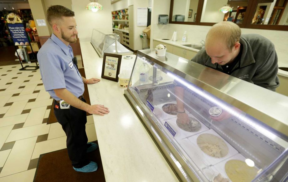 Employee Robert Hilty is served ice cream by Matthew Danesi in the parlor at Blue Bell Creameries on Wednesday. The compaay restarted its largest plant in Brenham on Wednesday a milestone in its recovery from a listeria outbreak