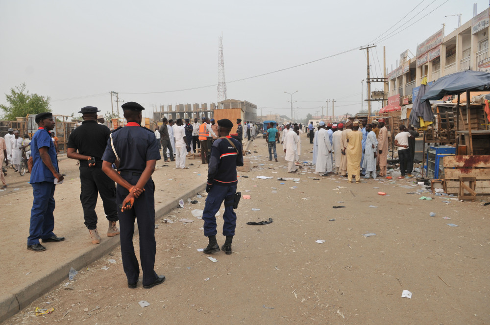 Security officers stand guard at the scene of an explosion at a mobile phone market in Kano Nigeria. Wednesday Nov. 18