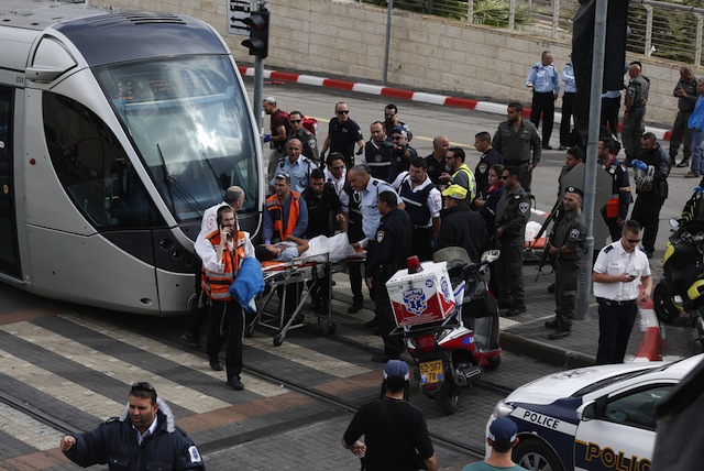 Israeli paramedics evacuate a wounded Palestinian boy who was shot after allegedly stabbing an Israeli security guard at a tramway station in Jerusalem